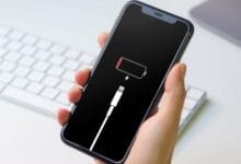 Un iPhone affichant plus de batterie, fond noir avec l'icône de la batterie en attente du rechargement. Améliorer l'autonomie de votre iPhone.