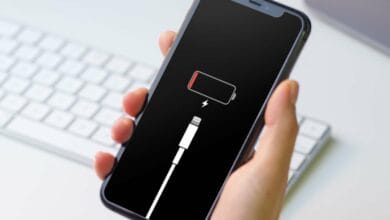 Un iPhone affichant plus de batterie, fond noir avec l'icône de la batterie en attente du rechargement. Améliorer l'autonomie de votre iPhone.